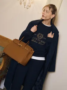 Close-up of navy blue sweatshirt featuring gold embroidery from a two-piece leisure set