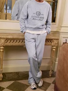 Close-up detail of gray sweatshirt and sweatpants set with elegant embroidery design