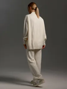 Back view of a chic cream knitted turtleneck sweater and matching trousers set