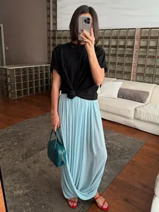 Détail d'une jupe longue drapée plissée tulipe bleu clair pour un look de style urbain.