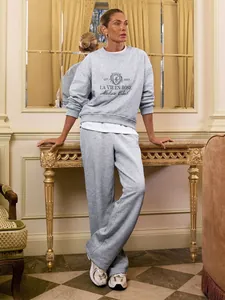 Elegant grey embroidered sweatshirt and matching joggers two-piece set worn by model