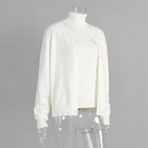 Detail shot of a white two-piece knitwear set including a turtleneck and a cardigan