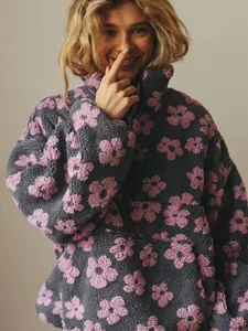 Macro view of the plush pink flower pattern on a dark grey oversized fleece sweatshirt.