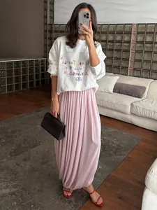 Jupe longue tulipe plissée rose élégante avec une silhouette drapée sophistiquée pour elle.