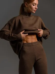 Close-up detail of a brown half-turtleneck knit sweater set showing texture and fit.