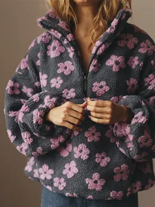 Close-up detail of cozy gray sherpa pullover featuring pink floral patterns and half-zip