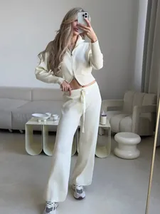 Detailed view of cream two-piece knit set featuring double zip cardigan and trousers
