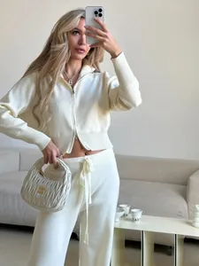 Detail view of cream two-piece knit set with double-zip sweater and matching pants