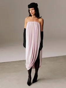 Élégante jupe longue plissée tulipe rose clair avec détail fendu drapé sur le mannequin