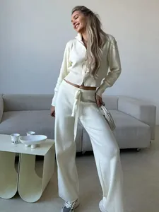 Full view of elegant cream two-piece knitwear set with zip-up sweater and wide-leg pants.