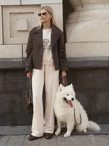 Lifestyle view of a cream embroidered sweatshirt and casual wide-leg pants set