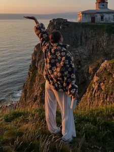 Cozy fleece flower print hoodie for women shown in a scenic outdoor sunset setting