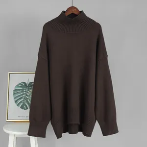 Maglione a dolcevita oversize marrone scuro in un ambiente interno semplice e curato