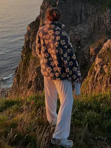 Floral polar fleece sweatshirt for women shown in a scenic coastal outdoor setting