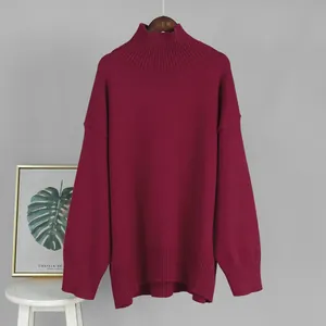 Dettaglio ravvicinato di un maglione bordeaux a collo alto con trama in maglia a coste.