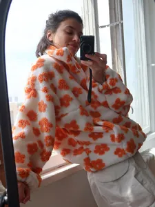 Model wearing cozy white fleece hoodie with vibrant orange flower pattern detail