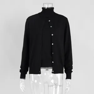 Detail of black two-piece knitwear set with high-neck top and buttoned cardigan.