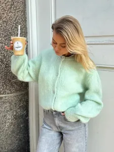 Stilvolle mintgrüne flauschige Strickjacke, getragen von einem Model im Freien