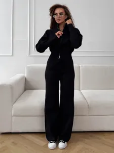 Model wearing black two-piece knit set with double-ended zipper and wide-leg pants