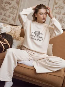 Detailed view of women's cream loungewear set with 'LA VIE EN ROSE' embroidery