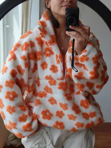 Close-up of women's fluffy floral fleece sweatshirt with orange flower patterns