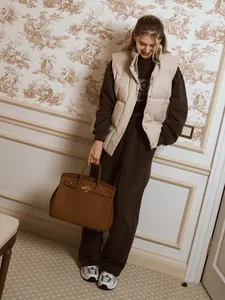 Dark brown embroidered sweatshirt and pants set styled with a beige puffer vest