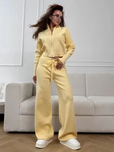 Close-up look of yellow knitted two-piece set with front zip sweater and wide-leg pants.