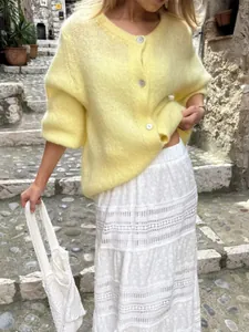 Süße gelbe Strickjacke mit einer Knopfleiste für Damen in herbstlicher Umgebung