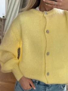 Detaillierte Nahaufnahme eines weichen gelben Mohair-Cardigans mit klassischen Knöpfen