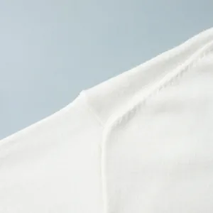 Vista macro dettagliata di un maglione lavorato a maglia bianca con cuciture sulle spalle