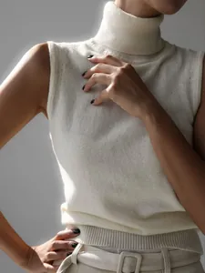 Close-up of elegant white knitted sleeveless turtleneck vest showing soft texture and fit.