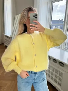 Detailansicht einer süßen, bonbonfarbenen, dünnen Strickjacke für Damen mit Knöpfen.