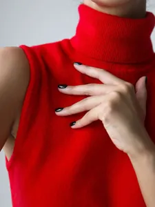 Close-up detail of soft red sleeveless knitted turtleneck sweater vest for women