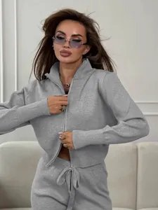 Detail view of a grey knitted two-piece set featuring a double zipper cardigan design.