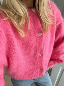Nahaufnahme einer weichen rosa Strickjacke mit Einreiher-Knöpfen aus Mohair