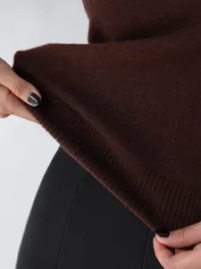 Close-up detail showing the ribbed hem and soft texture of a brown knit vest