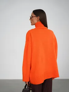 Vista posteriore di un maglione arancione a collo alto oversize da donna in studio.