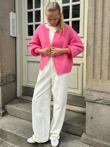 Stylische, bonbonrosa, einreihige Strickjacke mit weicher, flauschiger Textur an Model