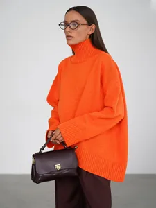 Dettaglio di un maglione a collo alto arancione oversize con collo alto a costine
