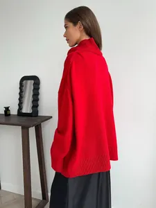 Vista laterale dettagliata di un maglione a dolcevita rosso oversize con polsini a coste
