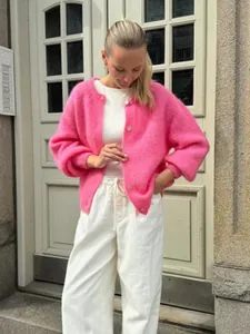 Detailansicht einer süßen rosa Strickjacke mit Knöpfen und einer weichen, mohairartigen Textur.