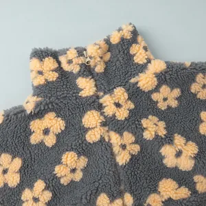 Macro detail of soft sherpa fleece sweater with yellow floral pattern and stand collar zipper