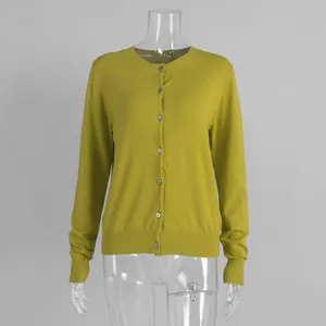 Macro detail of a mustard yellow knitted cardigan featuring front button closures.