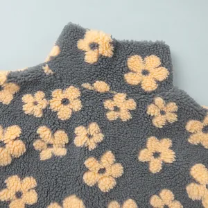 Close-up detail of soft sherpa fleece fabric showing yellow flower patterns on grey