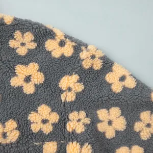 Close-up detail of grey fleece fabric with soft yellow floral pattern for warm sweatshirt