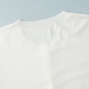 Detailed close-up showing the ribbed neckline texture of a soft white knitted sweater
