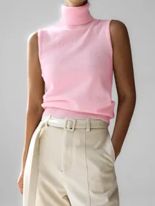 Detailed view of women's pink sleeveless turtleneck knit vest with minimalist design