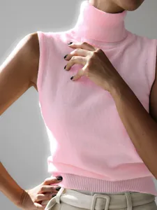 Close-up of pink sleeveless turtleneck knit vest showing soft ribbed texture and fit