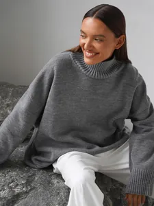 Primo piano del maglione a collo alto grigio oversize sulla modella in posa naturale