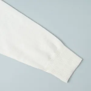 Close-up detail view of a white knit sweater sleeve showing the ribbed cuff texture